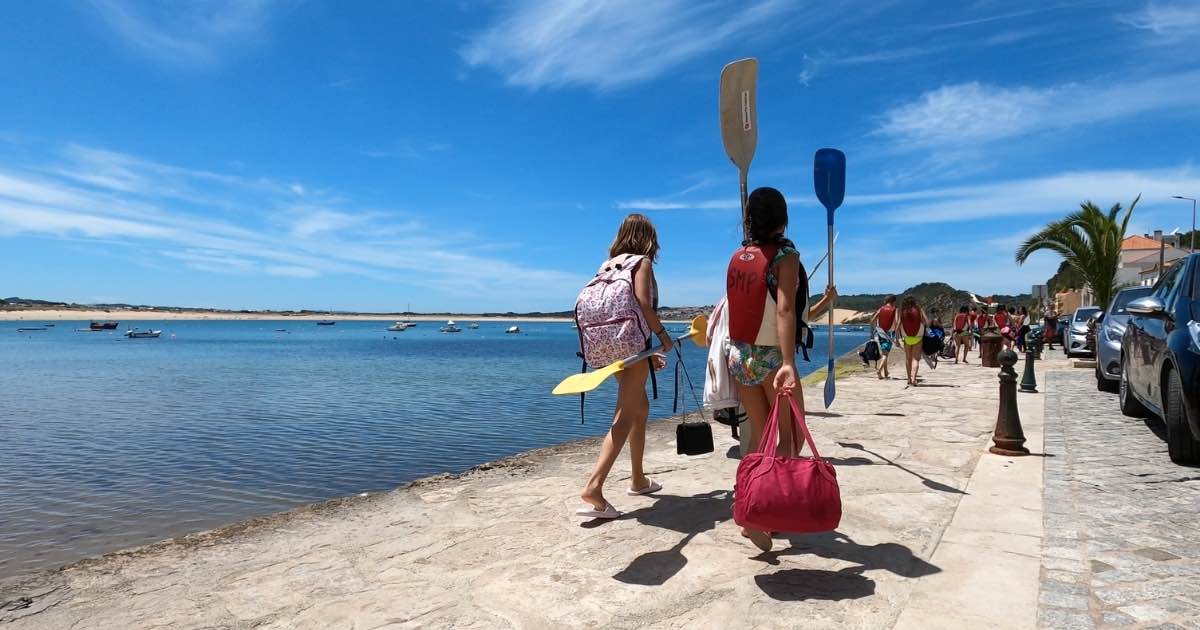 Children carrying kayak paddles along the pier at São Martinho do Porto Bay on Portugals Silver Coast